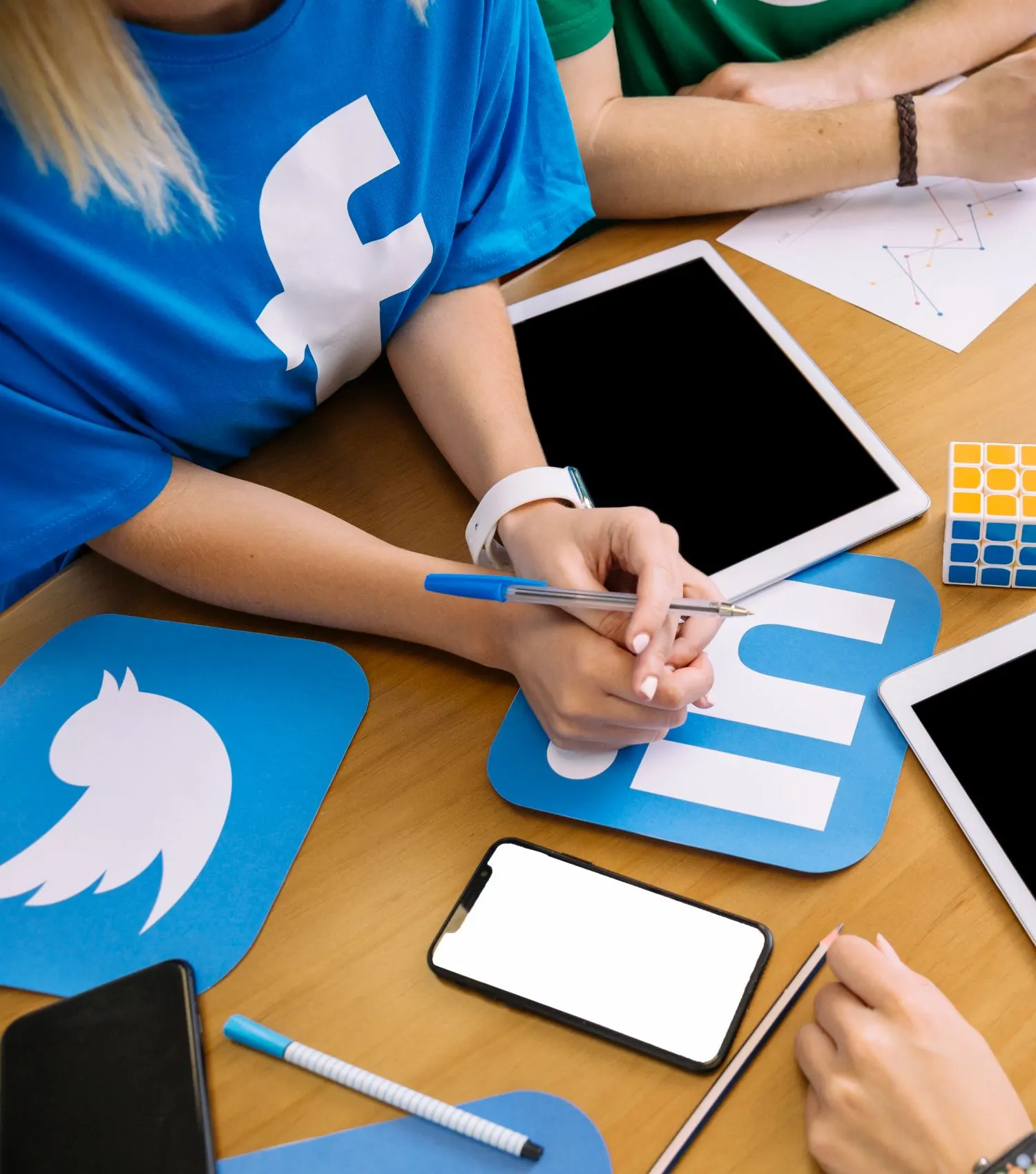 Mesa de trabajo con tabletas, móvil e iconos recortados de Facebook, Twitter y LinkedIn