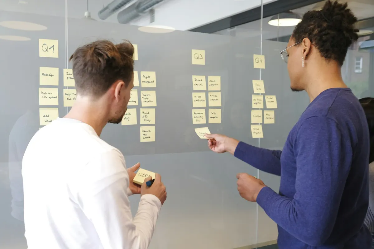 Dues persones organitzant un projecte amb notes adhesives