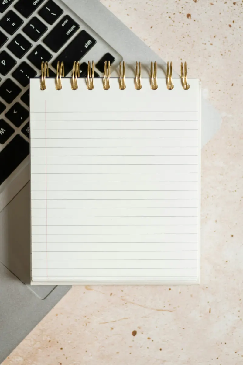 Libreta con notas sobre un portátil