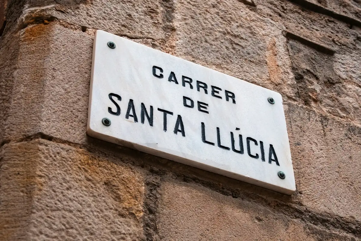 Placa del carrer de Santa Llúcia en una paret de pedra de Manresa
